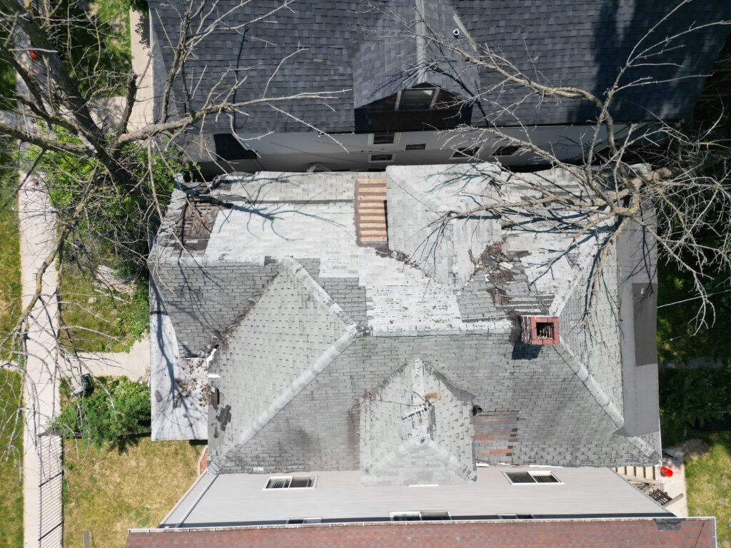 Roof Over 20 Years Old Close-up of an old roof with faded, curling shingles and visible damage from years of wear and weather exposure.